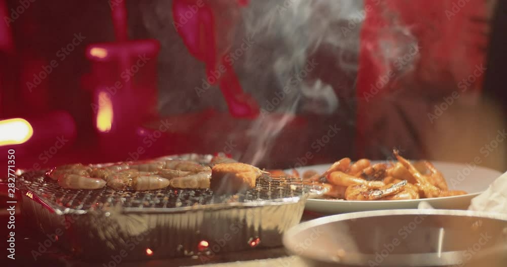 Close-up of female chef hands preparing grilled shrimps on table street food. Young caucasian woman cooking seafood as snacks for friends picnic. Close-up of female chef hands preparing grilled shrimps on table street food. Young caucasian woman cooking seafood as snacks for friends picnic.
