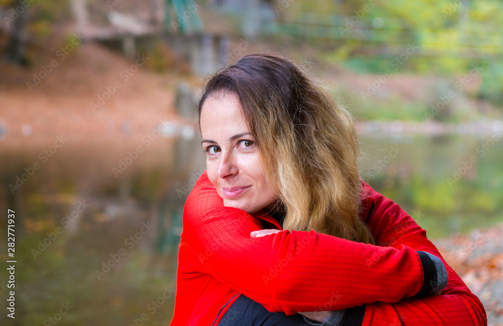 Beautiful young woman enjoying autumn by the side of a wild lake Beautiful young woman enjoying autumn by the side of a wild lake