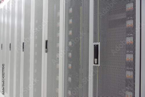 Close-up of a white metal grid cabinet with neatly arranged data centers