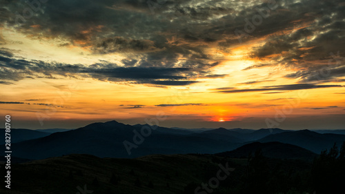Stunning sunset in the mountains. Orange sky and mountains silhouettes. Carpathian Mountains. Bieszczady. Poland © Szymon Bartosz