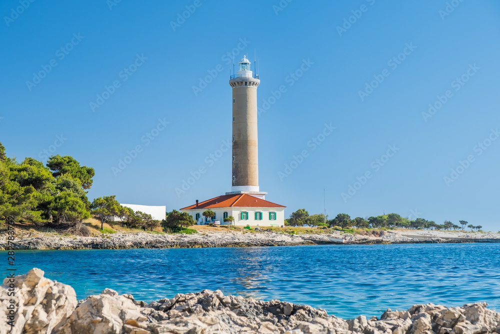 Croatia, island of Dugi Otok, old lighthouse of Veli Rat on the stone shore, beautiful seascape in foreground