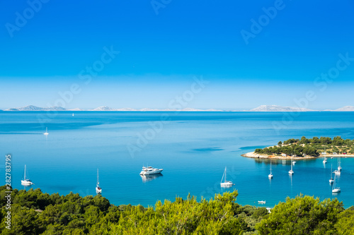 Panoramic view on Kosirina beach lagoon on Murter island in Croatia  anchored sailing boats and yachts on blue sea