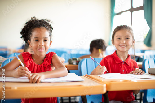 Smiling elementary school kids in classroom