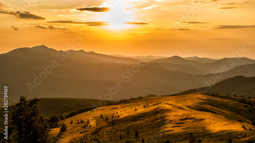 Stunning sunset in the mountains. Orange sky and mountains silhouettes. Carpathian Mountains. Bieszczady. Poland