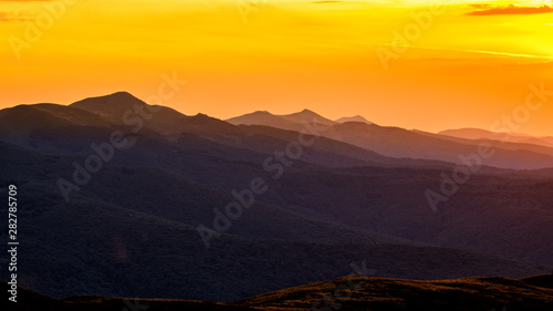 Stunning sunset in the mountains. Orange sky and mountains silhouettes. Carpathian Mountains. Bieszczady. Poland