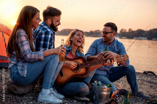 Friends enjoying music on the beach © ivanko80