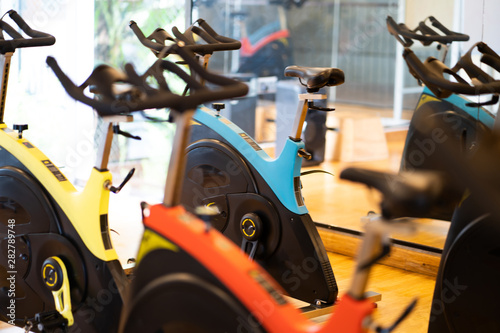 spinning exercise bikes gym room with many in a row