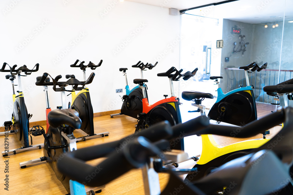 Fototapeta premium spinning exercise bikes gym room with many in a row