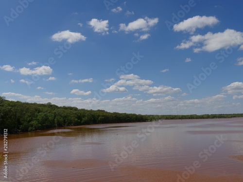 Beautiful clouds over the reddish waters of Thunderbird Lake, Oklahoma.