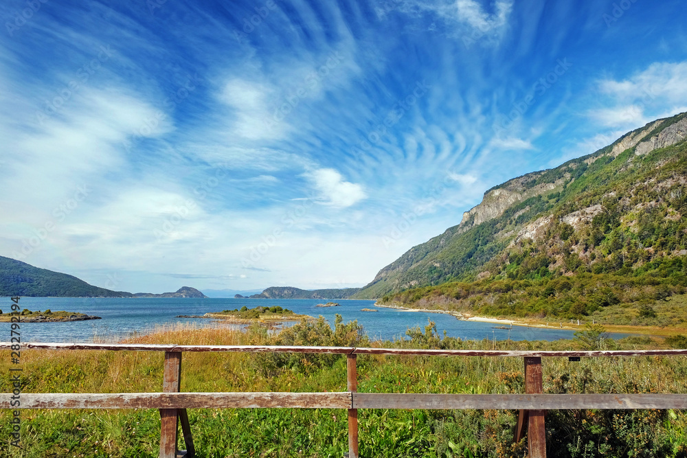 Panoramic view of Tierra del Fuego National Park, showing small islands surrounded by green vegetation and water, against a blue sky. Panoramic view of Tierra del Fuego National Park, showing small islands surrounded by green vegetation and water, against a blue sky.