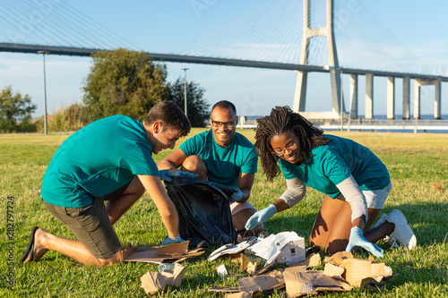 Canvas Print Happy volunteer team cleaning green city area from garbage