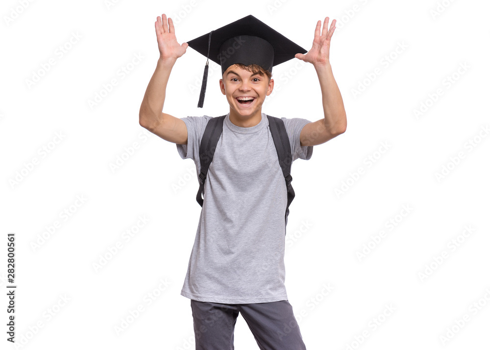 Young graduate student - Happy teen boy in bachelor hat with backpack, isolated on white background. Smiling child In Corner-Cap looking at camera. Cheerful teenager in Graduation Cap Back to school. Young graduate student - Happy teen boy in bachelor hat with backpack, isolated on white background. Smiling child In Corner-Cap looking at camera. Cheerful teenager in Graduation Cap Back to school.
