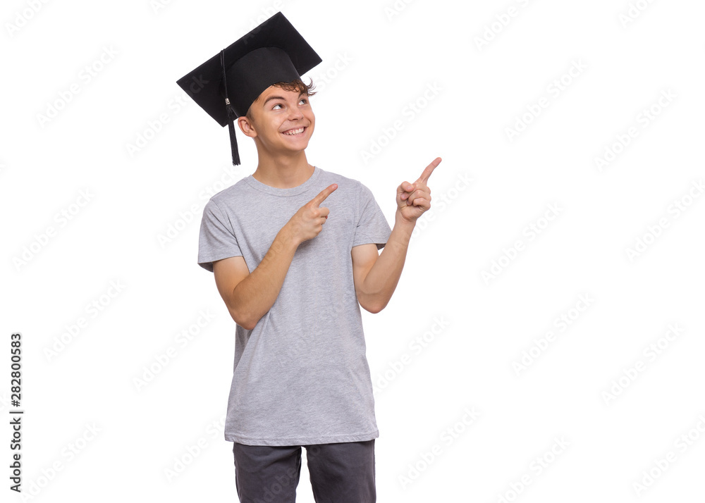Graduate student teen boy in bachelor hat pointing fingers away at copyspace, isolated on white background. Smiling child pointing fingers at something. Teenager guy in Graduation Cap Back to school. Graduate student teen boy in bachelor hat pointing fingers away at copyspace, isolated on white background. Smiling child pointing fingers at something. Teenager guy in Graduation Cap Back to school.