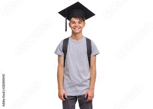 Young graduate student - Happy teen boy in bachelor hat with backpack, isolated on white background. Smiling child In Corner-Cap looking at camera. Teenager guy in Graduation Cap Back to school.