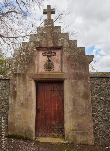 A large wooden studded Door set into a high stone wall, leading into a Walled garden on a property in Blairgowrie, Perthshire, Scotland
