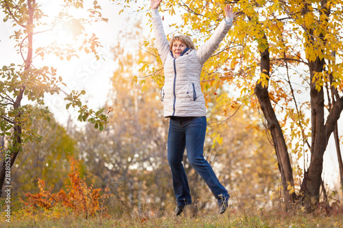 A woman walks in the Park in the autumn, around the yellow and red leaves.