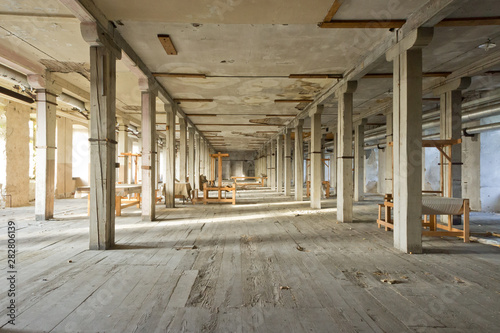Bâtiment industriel abandonné en ruine, intérieur avec des piliers en perspective, avec une atmosphère poussiéreuse photo