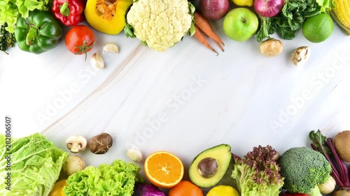 Overhead view of colorful fresh organic vegetables on marble texture background stop motion with copy space in the middle