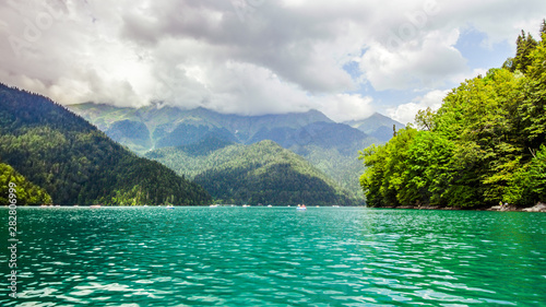 Natural landscape. Panorama view of the lake Small Ritsa. Trees reflecting in the blue from lapis lazuli water. Ritsa National Park, Abkhazia