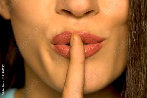 Closeup of woman with her finger on her lips