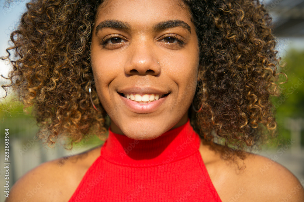 Happy joyful African American college girl posing for camera. Closeup of young black woman in casual smiling at camera. Lifestyle concept Happy joyful African American college girl posing for camera. Closeup of young black woman in casual smiling at camera. Lifestyle concept