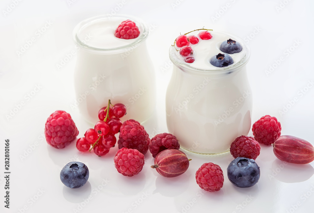 Different ripe berries and homemade yogurt on a white light background.. Good breakfast. soft selective focus. Different ripe berries and homemade yogurt on a white light background.. Good breakfast. soft selective focus.