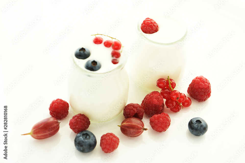 Different ripe berries and homemade yogurt on a white light background.. Good breakfast. soft selective focus. Different ripe berries and homemade yogurt on a white light background.. Good breakfast. soft selective focus.