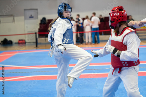  two girls in blue and red Taekwondo equipment are fighting at doyang