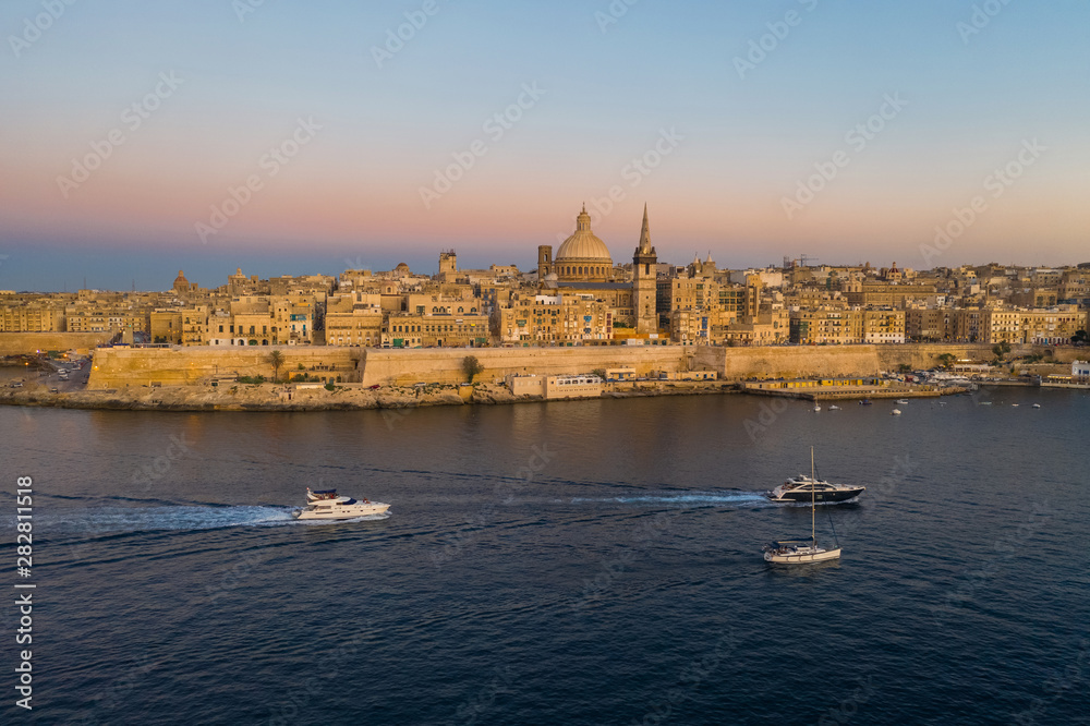 Valletta - capital of Malta. Aerial view of Valletta Skyline in the evening, Sunset. Boats on the sea.