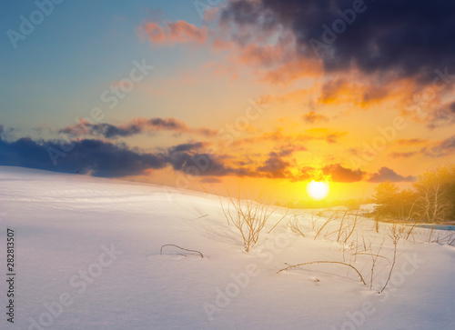 winter snowbound plain at the dramatic sunset