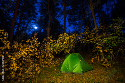 night touristic camp scene  green touristic tent in a autumn forest at the night