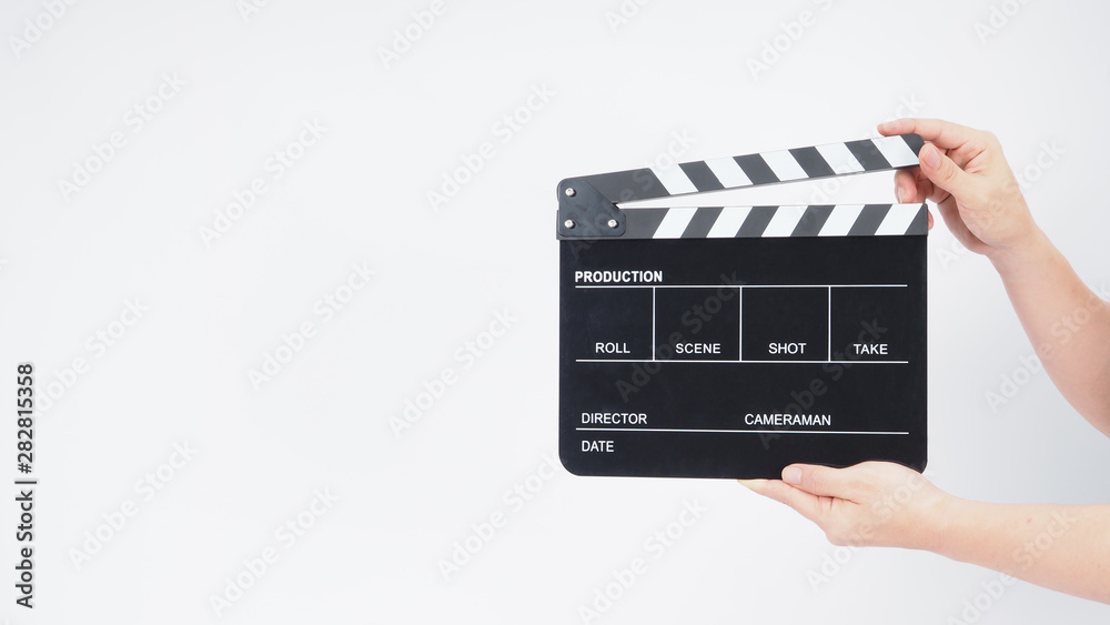A man's hands is holding black Clapperboard or movie slate. it use in video production ,film, cinema industry.It is white background.