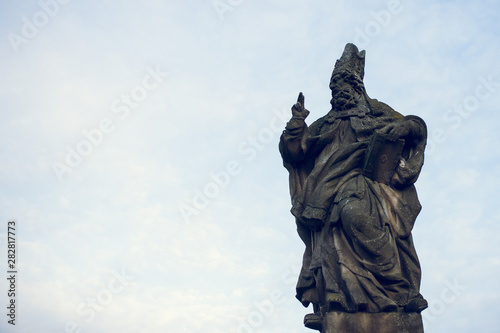 St. Adalbert statue on Charles Bridge in Prague  Czech Republic. Medieval Gothic bridge  finished in the 15th century  crossing the Vltava River