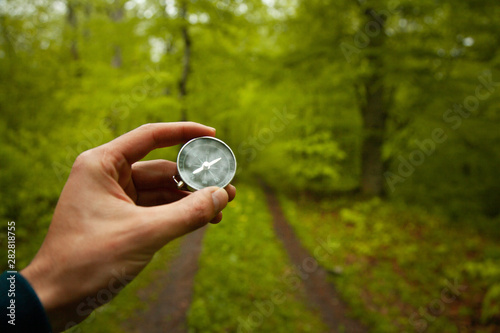 man hand compass in forest
