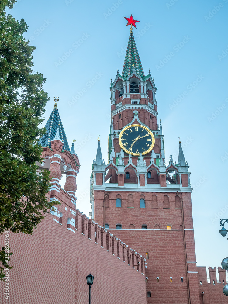 Spasskaya tower, clock tower exit to Red Square, wall of Kremlin under twilight evening sky, Moscow, Russia Spasskaya tower, clock tower exit to Red Square, wall of Kremlin under twilight evening sky, Moscow, Russia