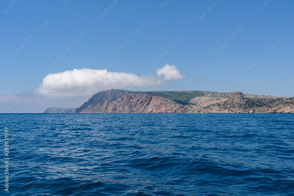the endless expanses of the black sea, rich blue, on a bright sunny day with clouds in the sky, from the side of a pleasure boat in the black sea.