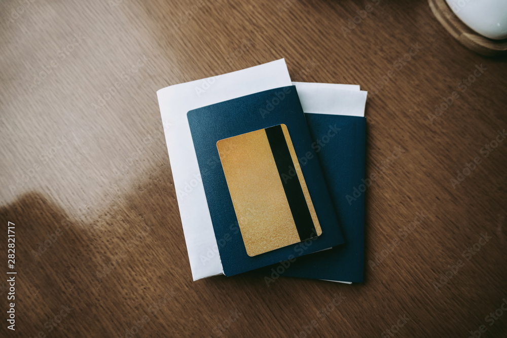 Business air trip concept. Passports with documents and travel insurance with gold credit card on the table.