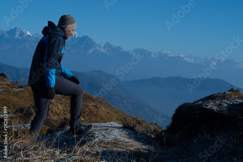 Happy man standing on cliff and looking at landscape view