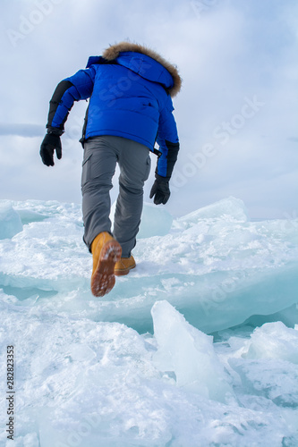 Man walking on  ice in frozen lake at Lake Bikal, Russia photo