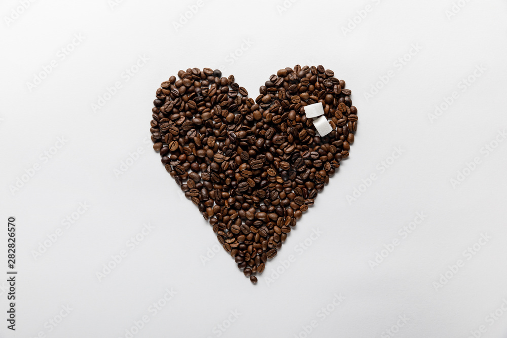 top view of heart made of coffee grains with sugar on white background top view of heart made of coffee grains with sugar on white background