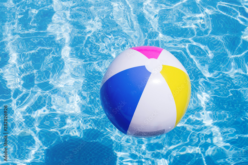 Children's bright beach ball in swimming pool
