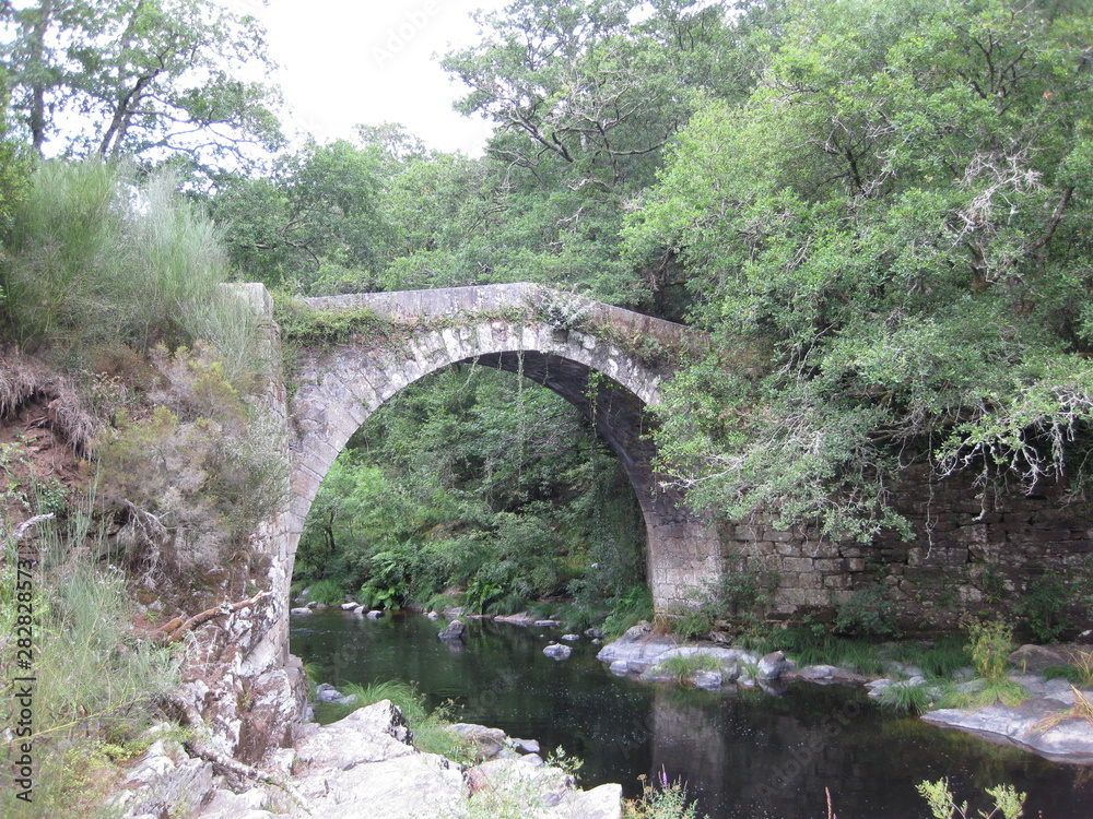 Silleda,Spain-July,26, 2019:bridge of the demo situated on the reza river Silleda,Spain-July,26, 2019:bridge of the demo situated on the reza river