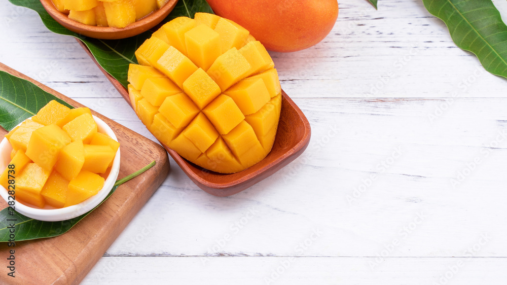 Fresh chopped mango on a tray and bright rustic wooden background. Tropical summer fruit design concept, close up, macro, copy space. Fresh chopped mango on a tray and bright rustic wooden background. Tropical summer fruit design concept, close up, macro, copy space.