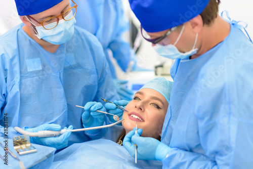 Dentist Doctor and his Team Treating a Patient photo