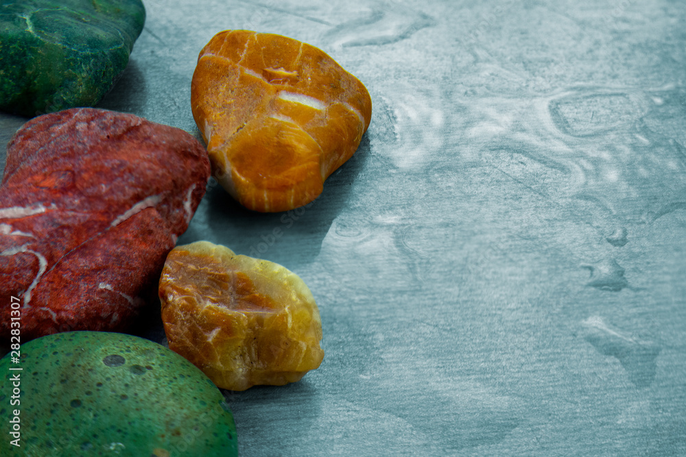 Colored stones close up image on surface with water drops. Abstract background or natural landscape of mineral elements Colored stones close up image on surface with water drops. Abstract background or natural landscape of mineral elements