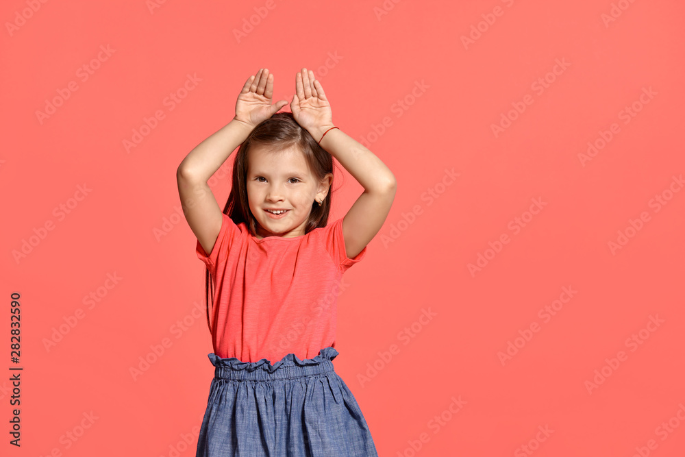 Close-up studio shot of beautiful brunette little girl posing against a blue background. Close-up studio shot of beautiful brunette little girl posing against a blue background.