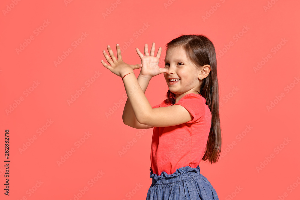 Close-up studio shot of beautiful brunette little girl posing against a blue background. Close-up studio shot of beautiful brunette little girl posing against a blue background.