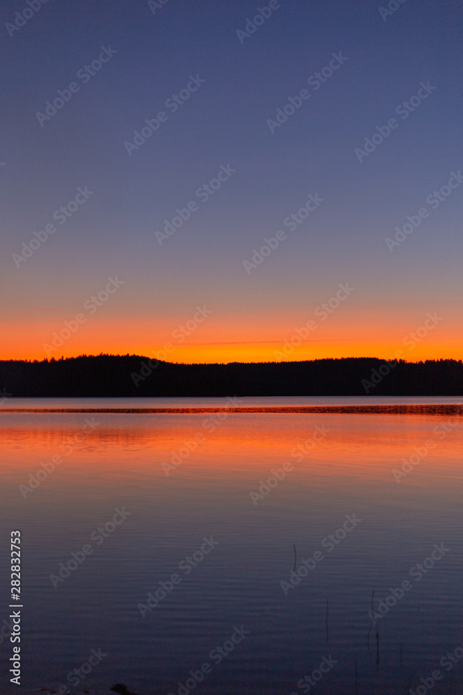 Lake sunset silhouette. Finnish lake landscape photo.