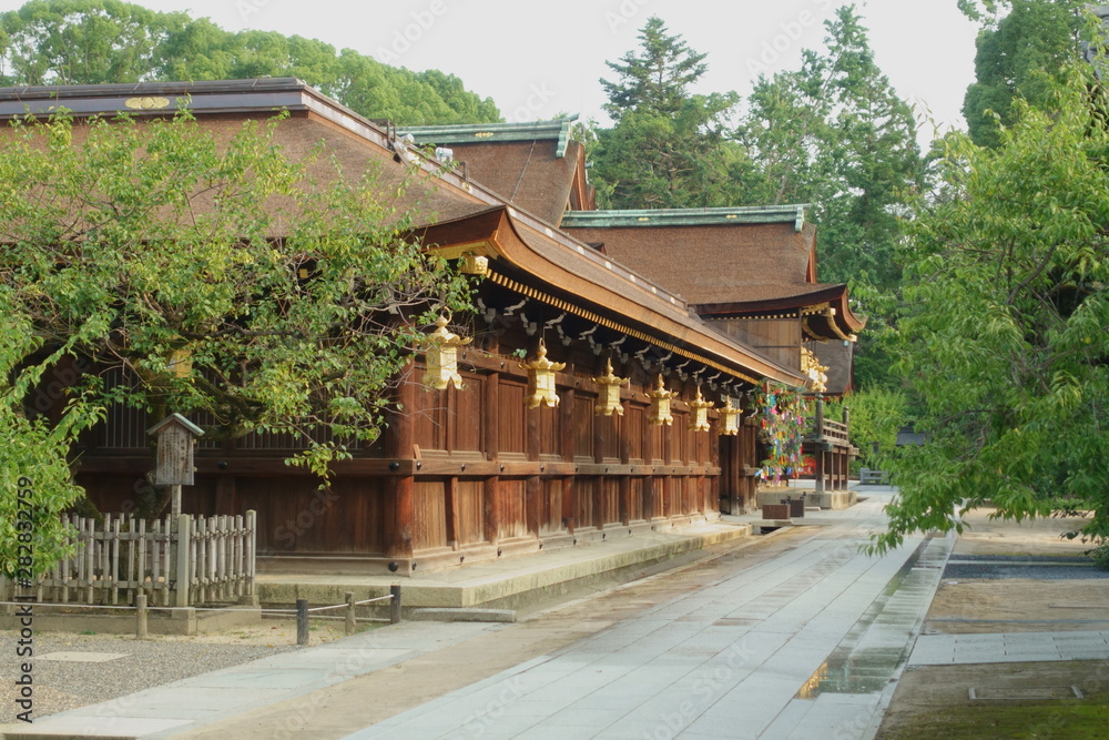 京都、北野天満宮の東回廊と拝殿の屋根が見える境内の風景