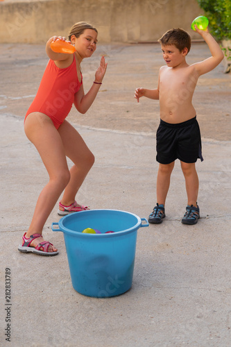 Boy and girl playing with Boy With Water Balloons.